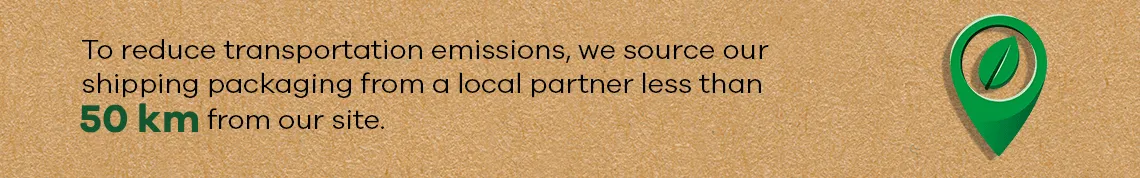 Green location symbol with leaf and text: shipping packaging sourced from partner under 50 km away to reduce emissions.